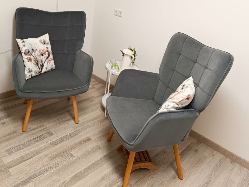 Komfortable graue Sessel mit dekorativen Kissen in der Praxis BalancePur