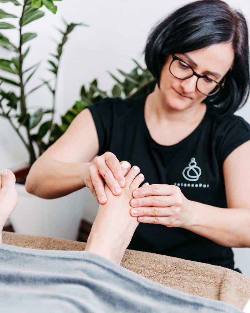 deep-balance-wohlbefinden-donnerskirchen Hand einer Klientin mit schwebenden Schmetterlingen im Sonnenlicht.
